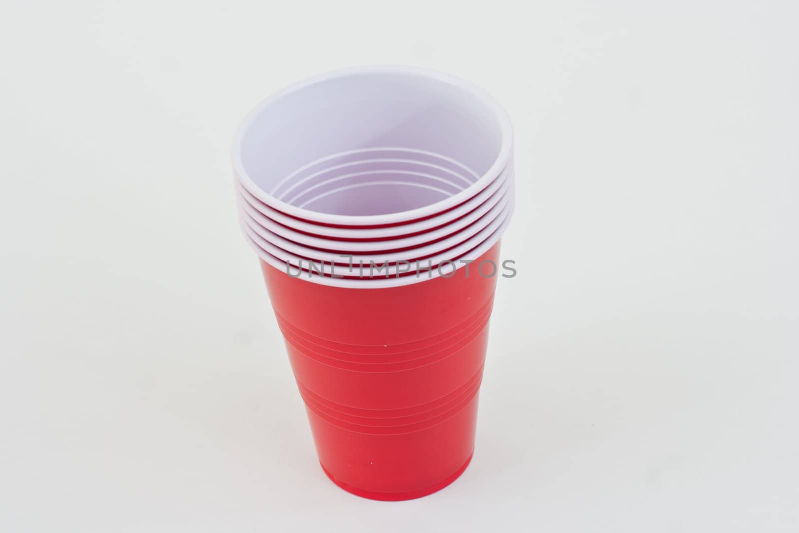 Red plastic cups in a stack on a white background.