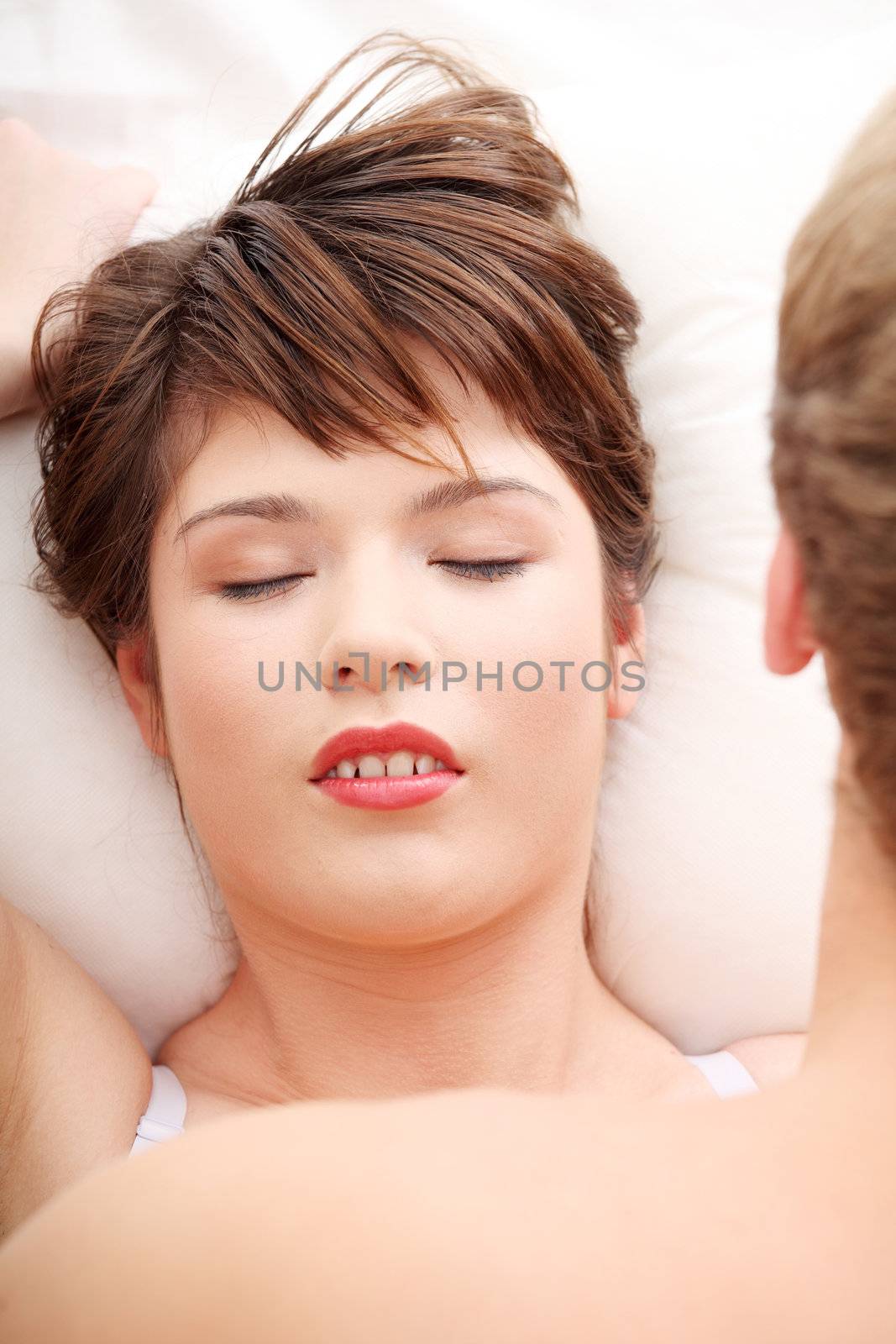 Beautiful young couple lying in bed.