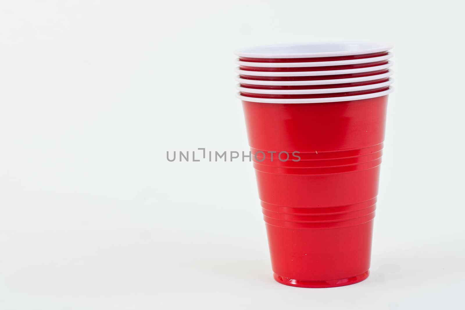 Red plastic cups in a stack on a white background.