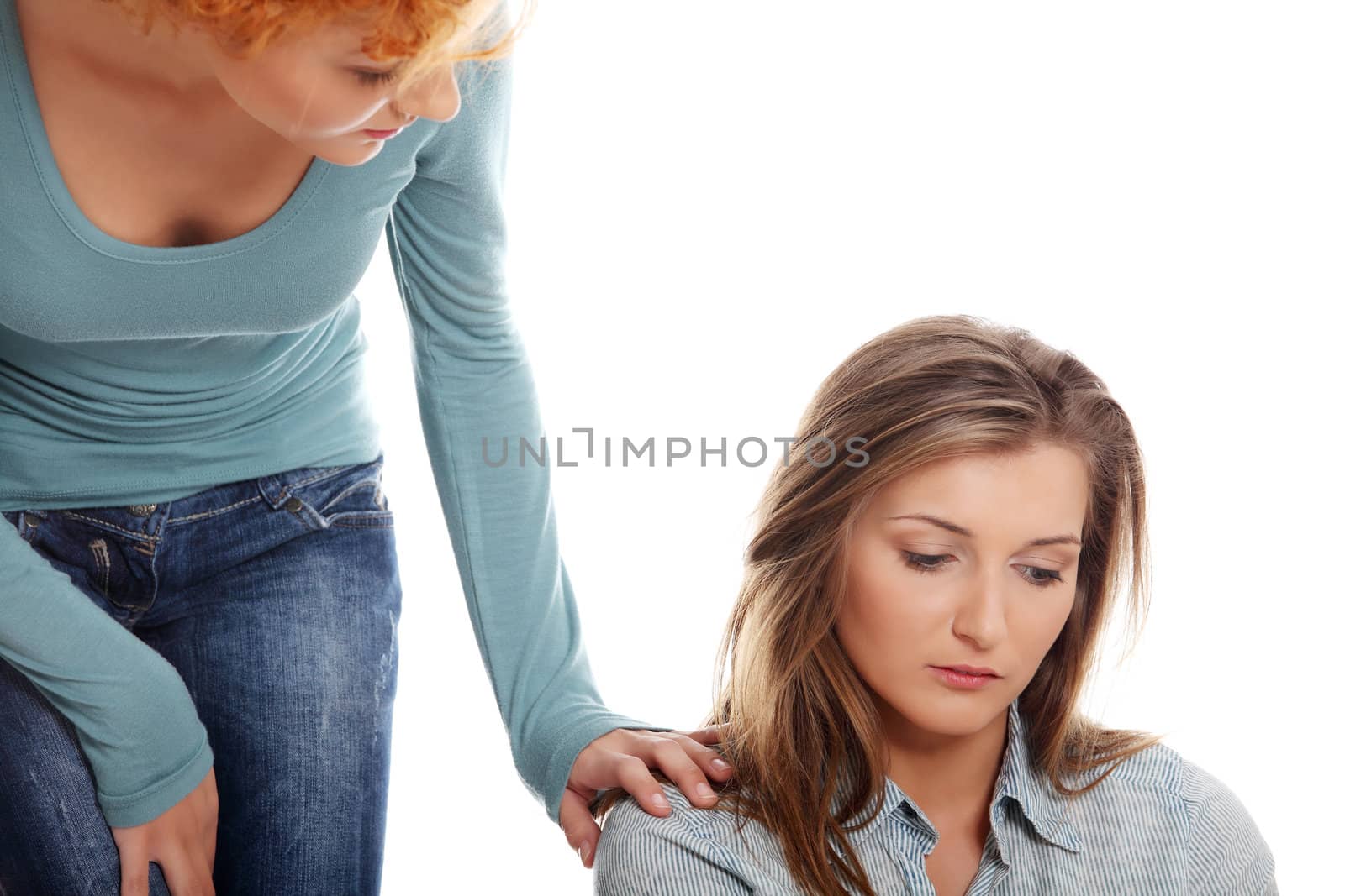 Troubled young girl comforted by her friend. Isolated on white background