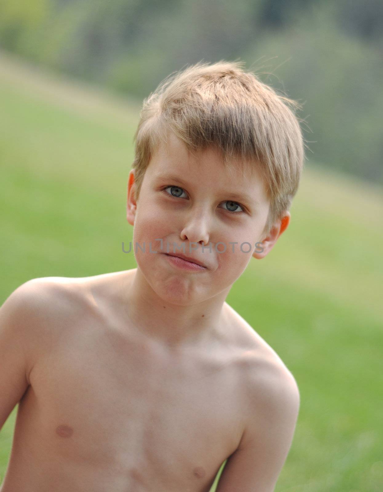 Smiling boy on a green background in forest