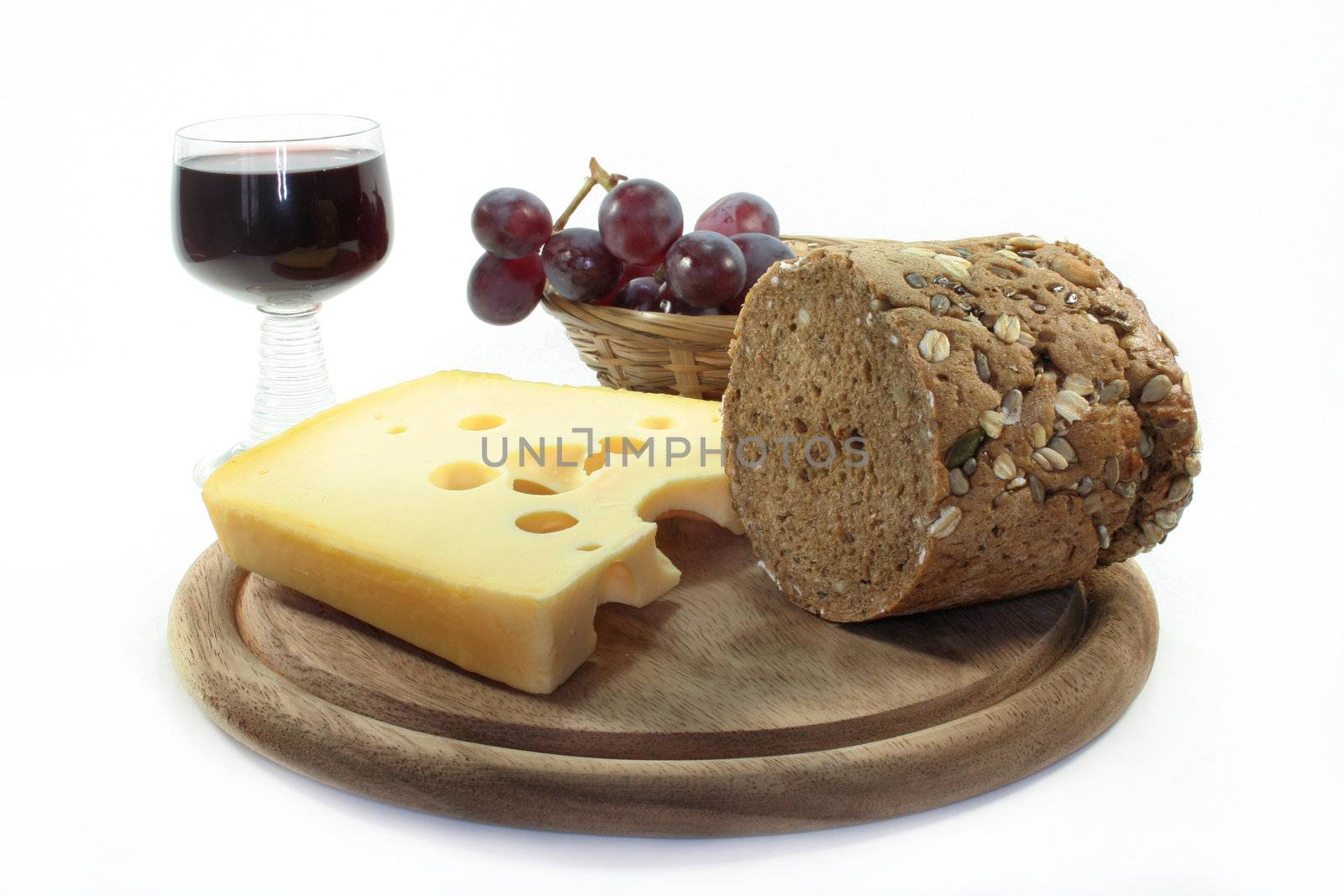 a piece of cheese and bread on a board and other goodies