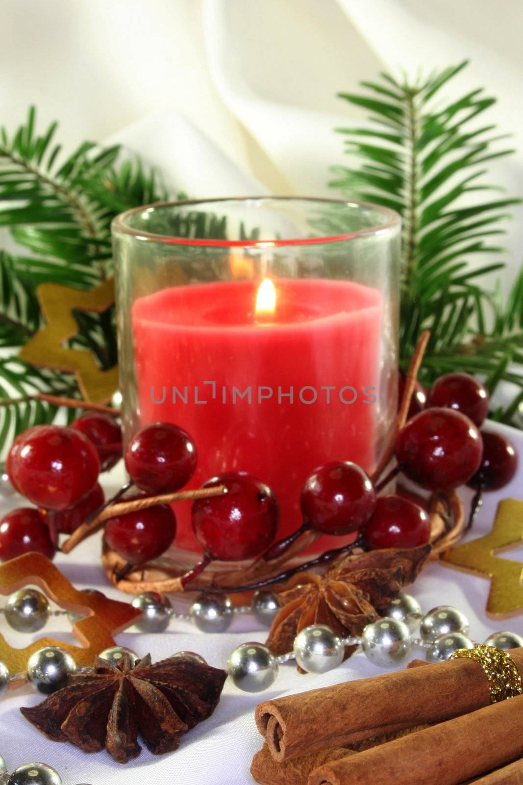 a burning candle with Christmas decorations