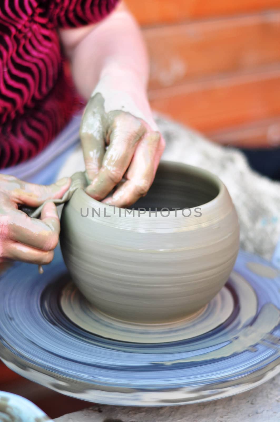 The hands of a potter creating an earthen jar