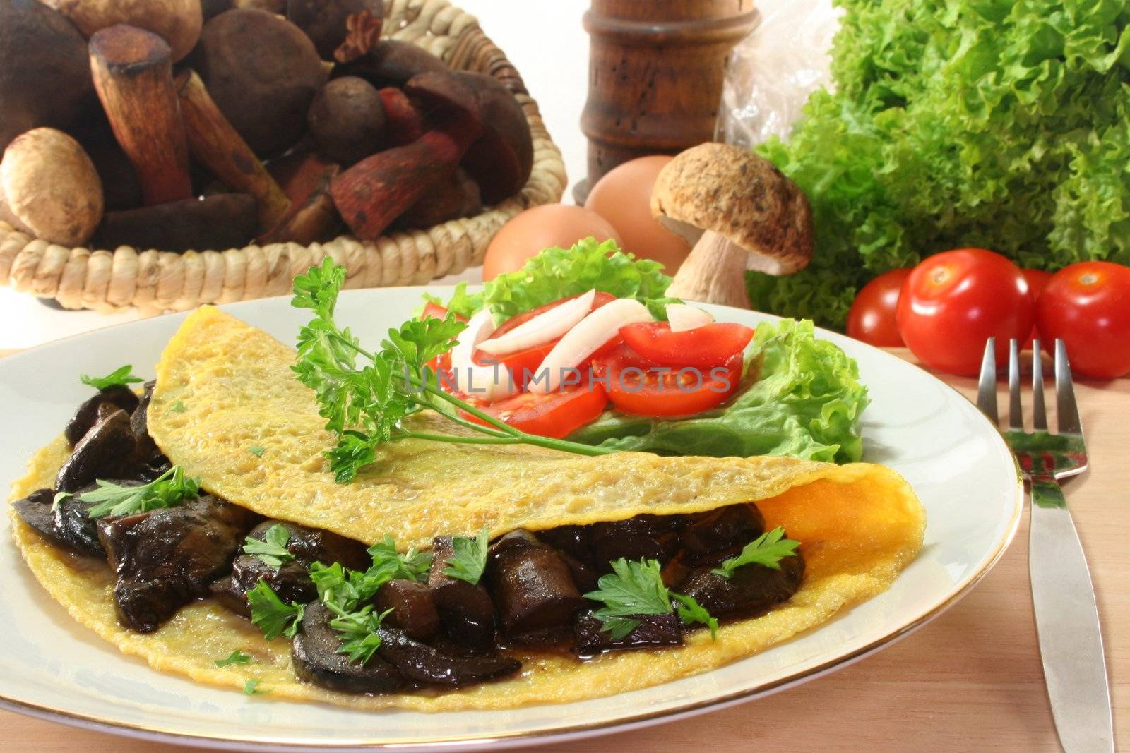 an omelet stuffed with wild mushrooms and fresh salad