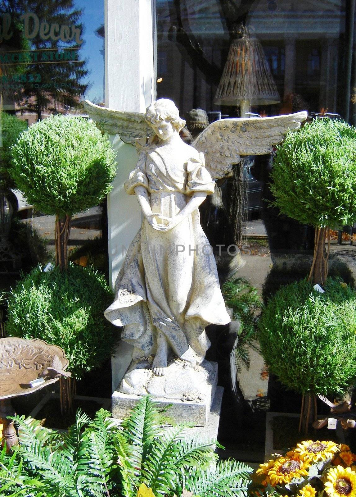 Angel with wings amongst shrubbery