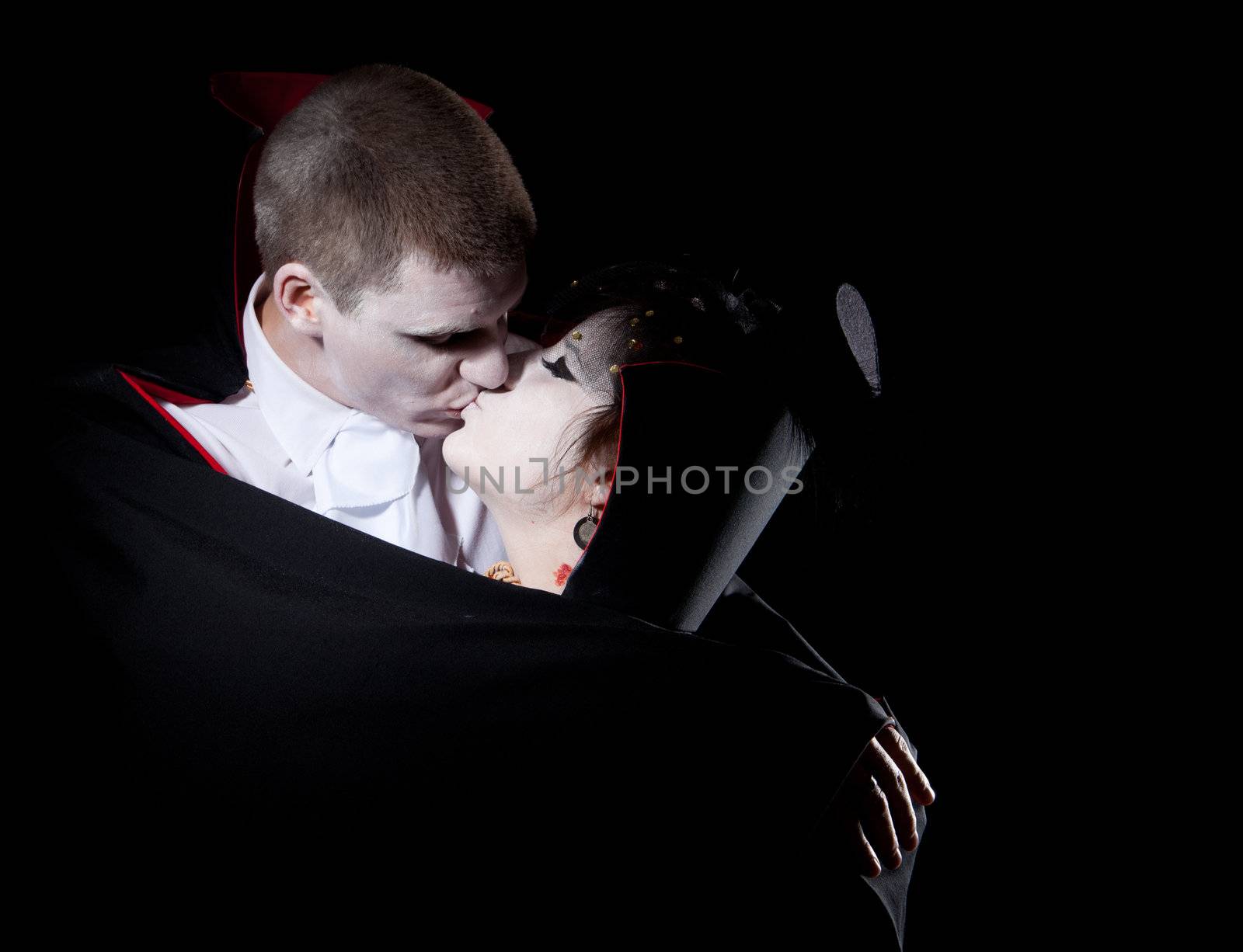 a vampire couple holding each other and kissing