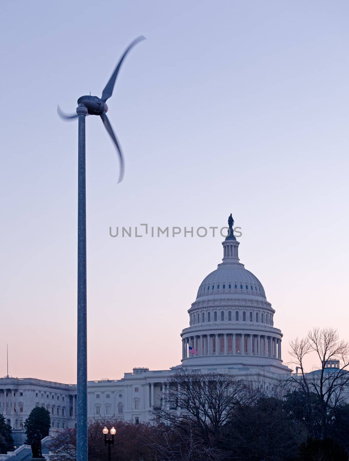 Brightly lit dawn sky behind the illuminated dome of the Capitol in Washington DC with the Statue of Freedom in the sunlight