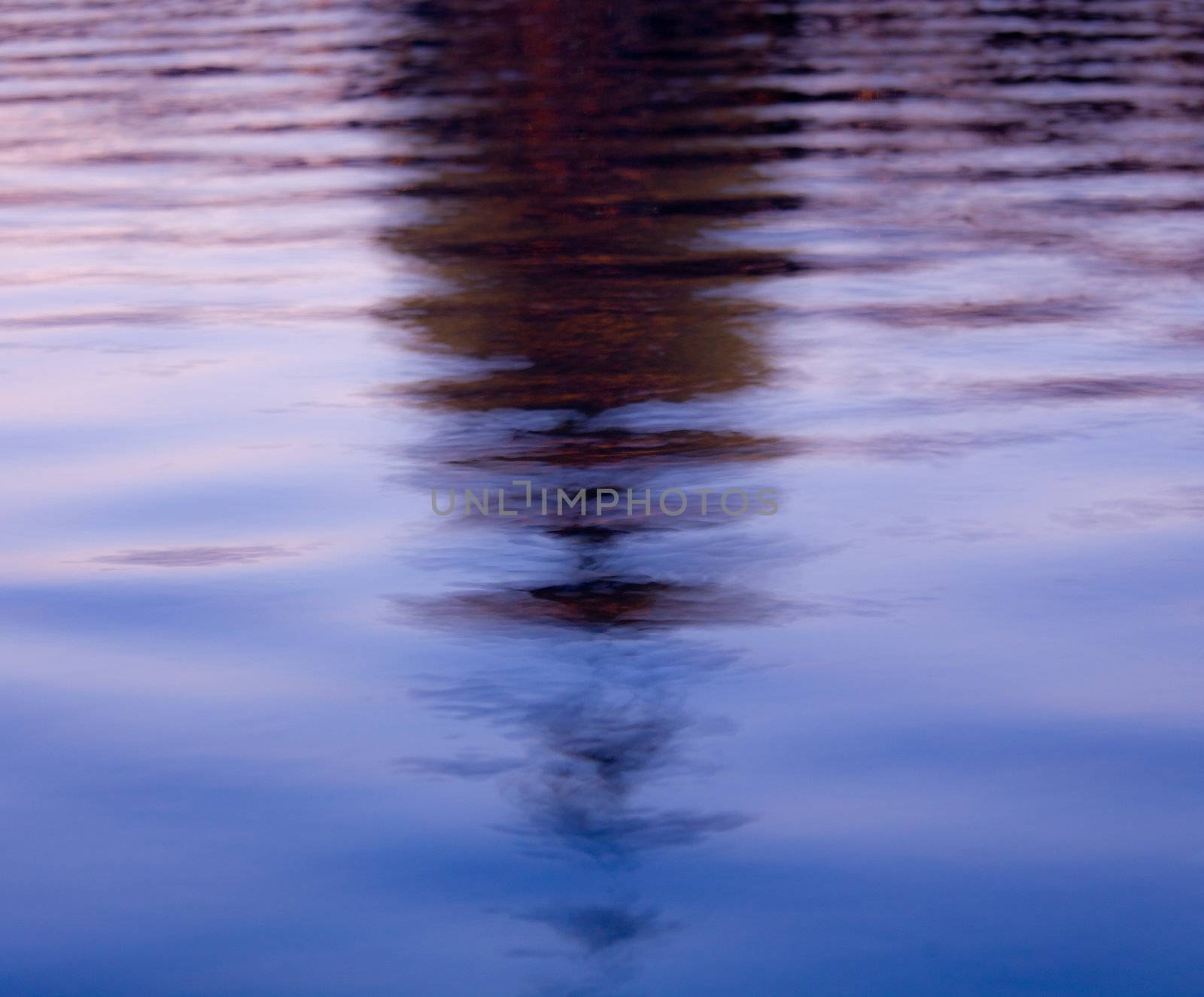 Brightly lit dawn sky behind the illuminated dome of the Capitol in Washington DC reflecting in the water of the pool in front of the building