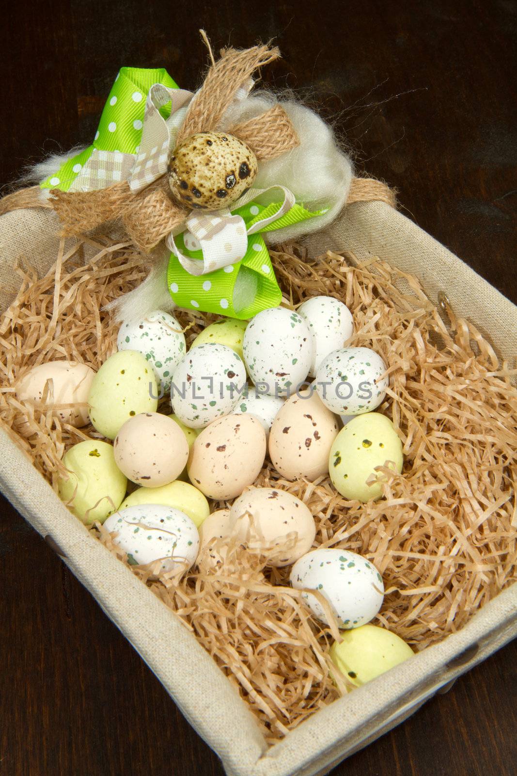 Colorful chocolate easter eggs in brown basket 