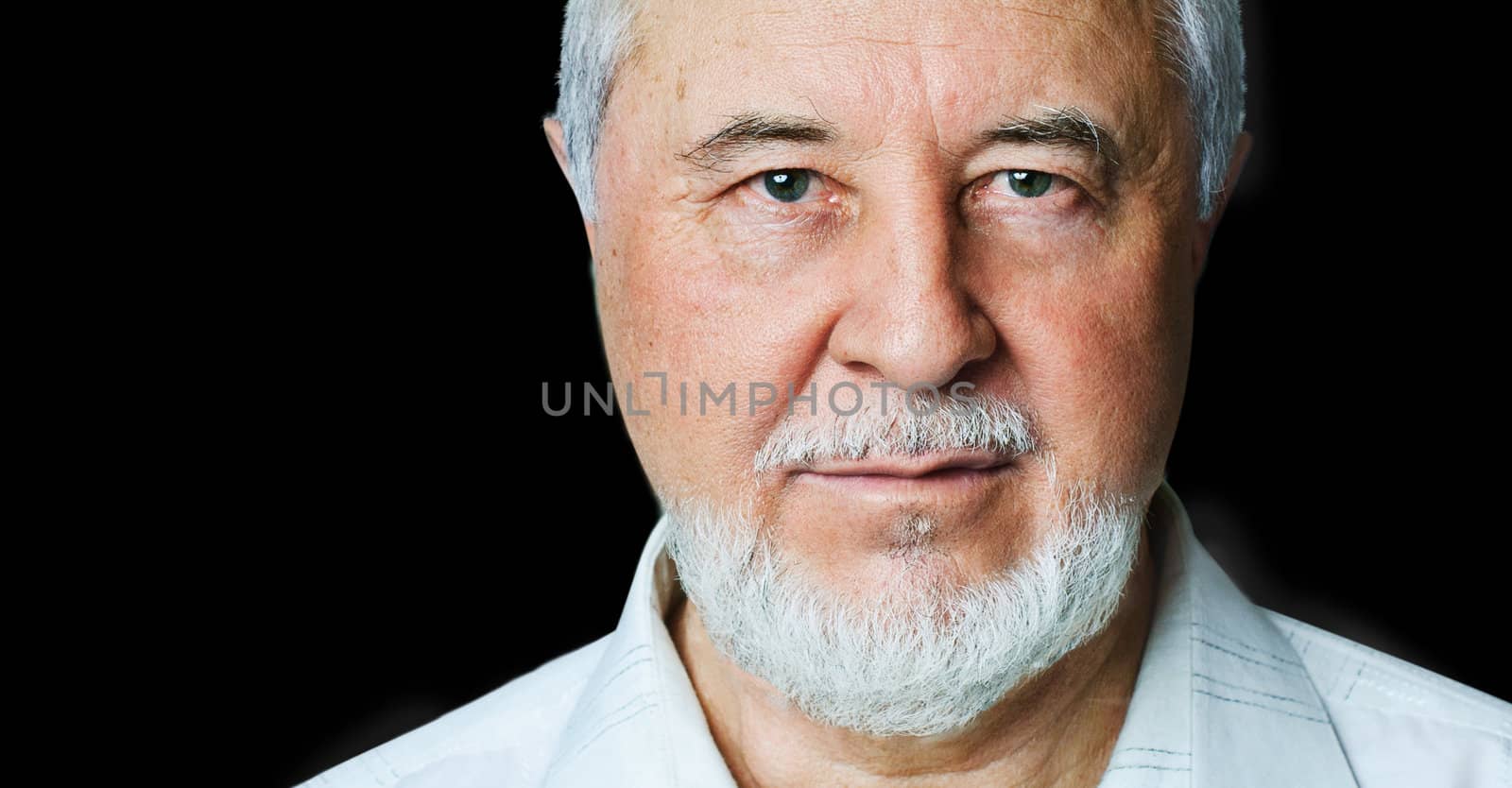 Portrait of a smiling senior closeup to the studio on a black background