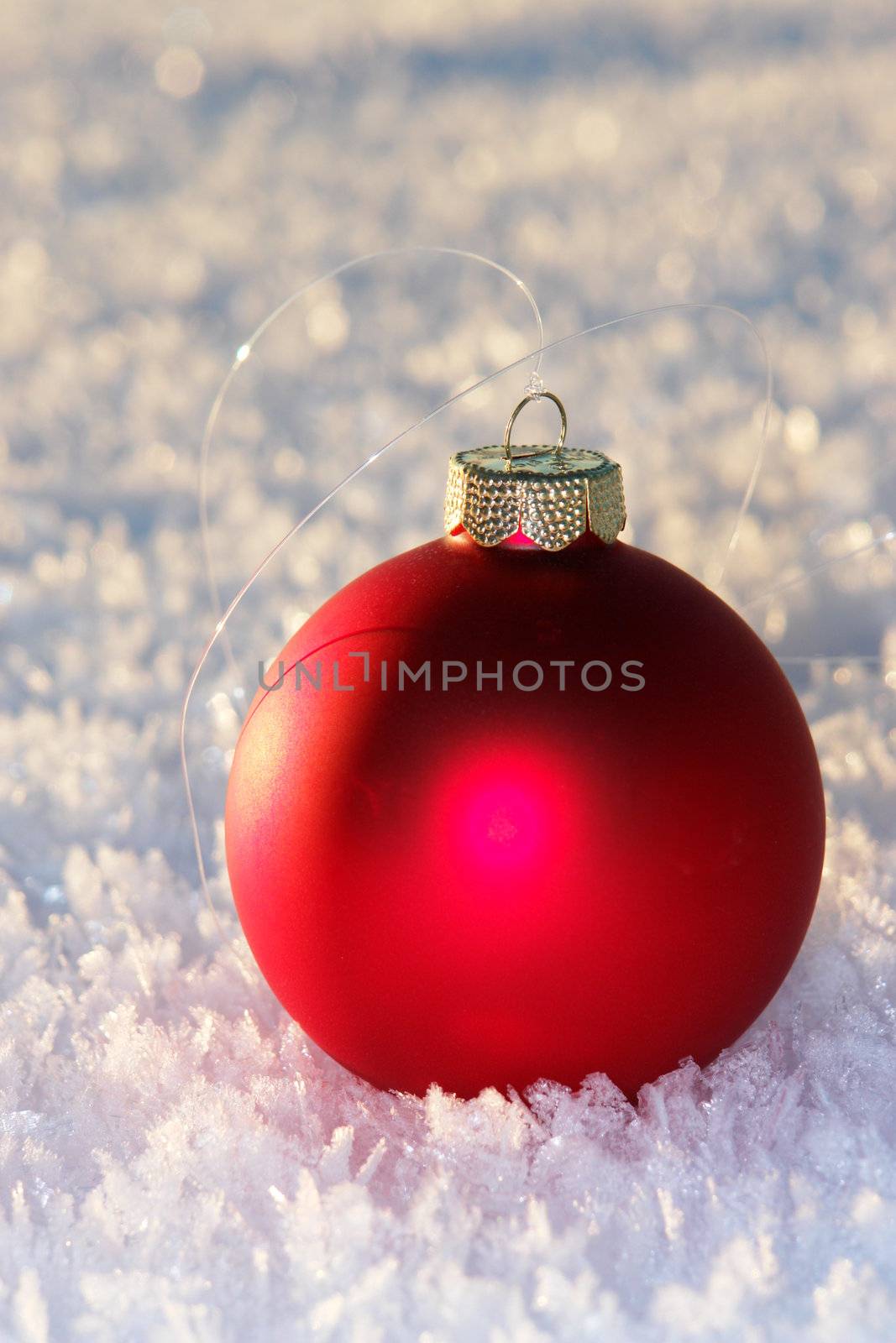 a red bauble in snowy winter landscape