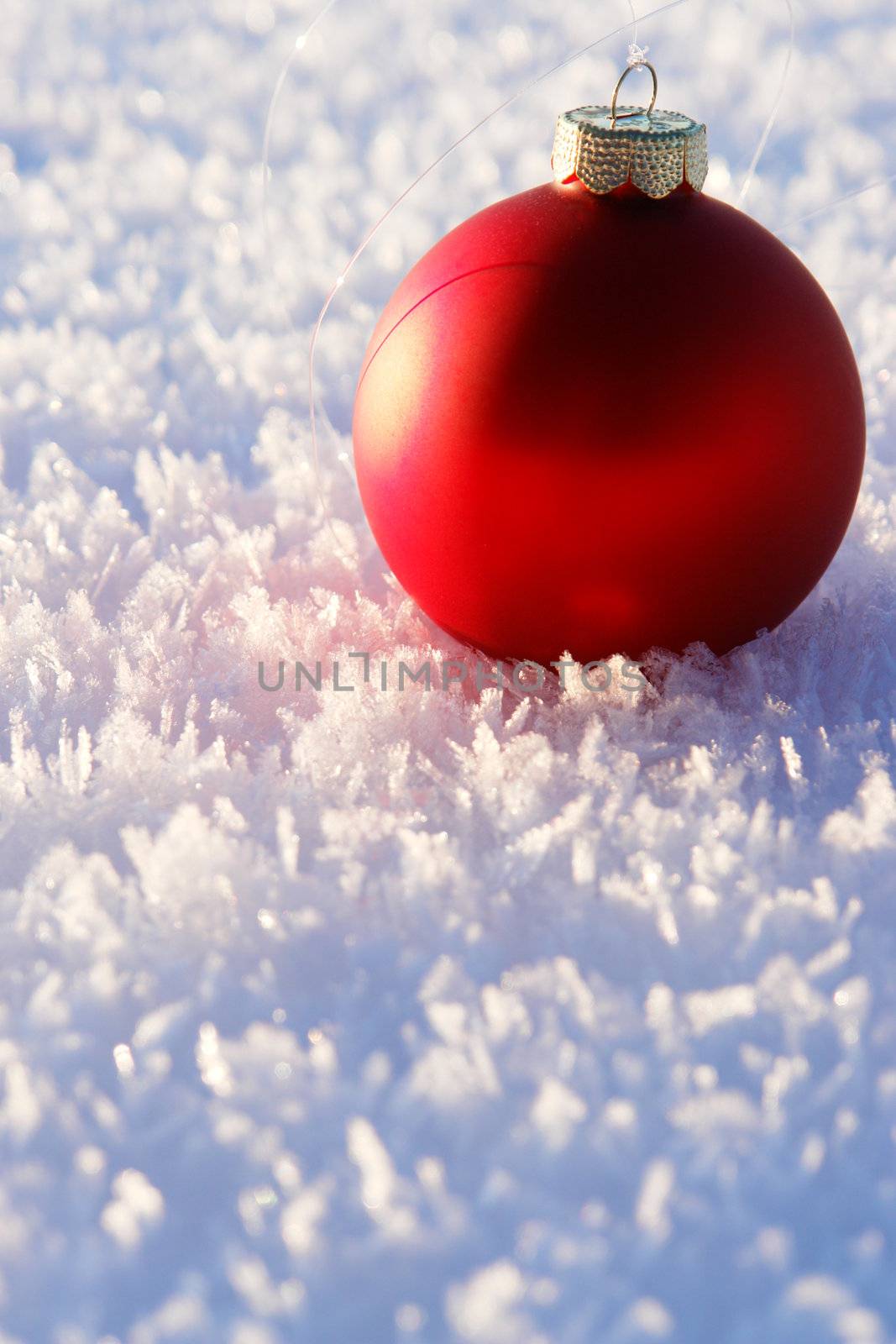 a red bauble in snowy winter landscape