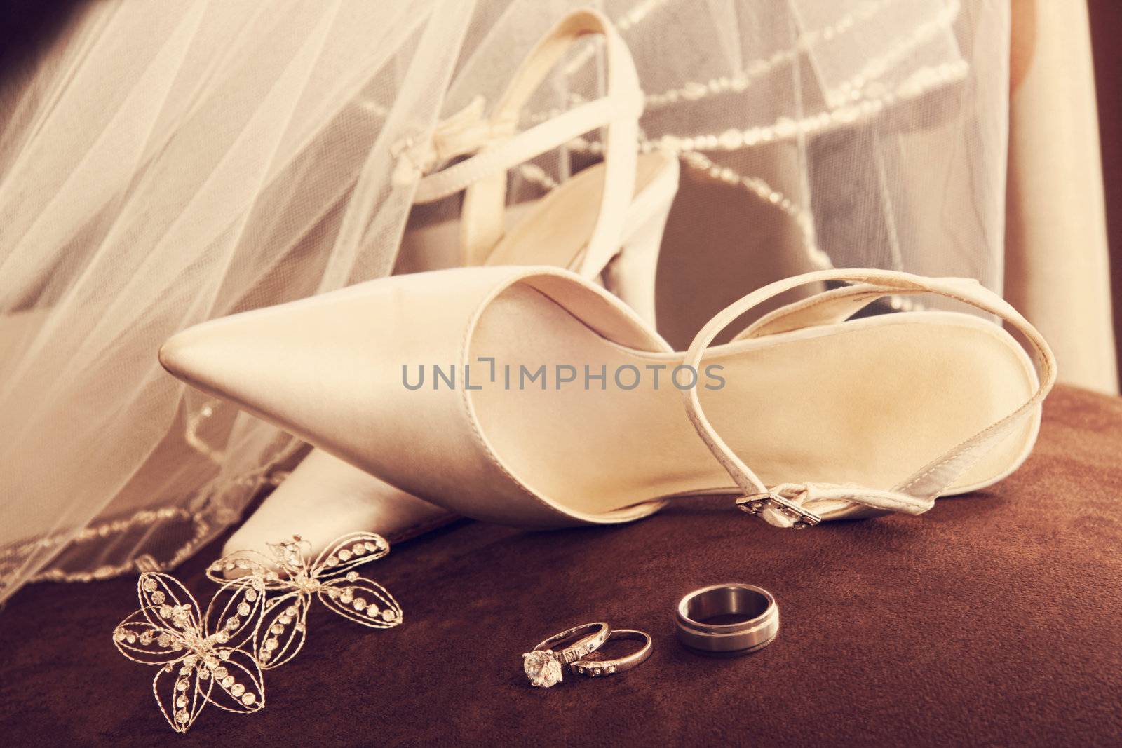 Wedding shoes with veil and rings on velvet chair by Sandralise