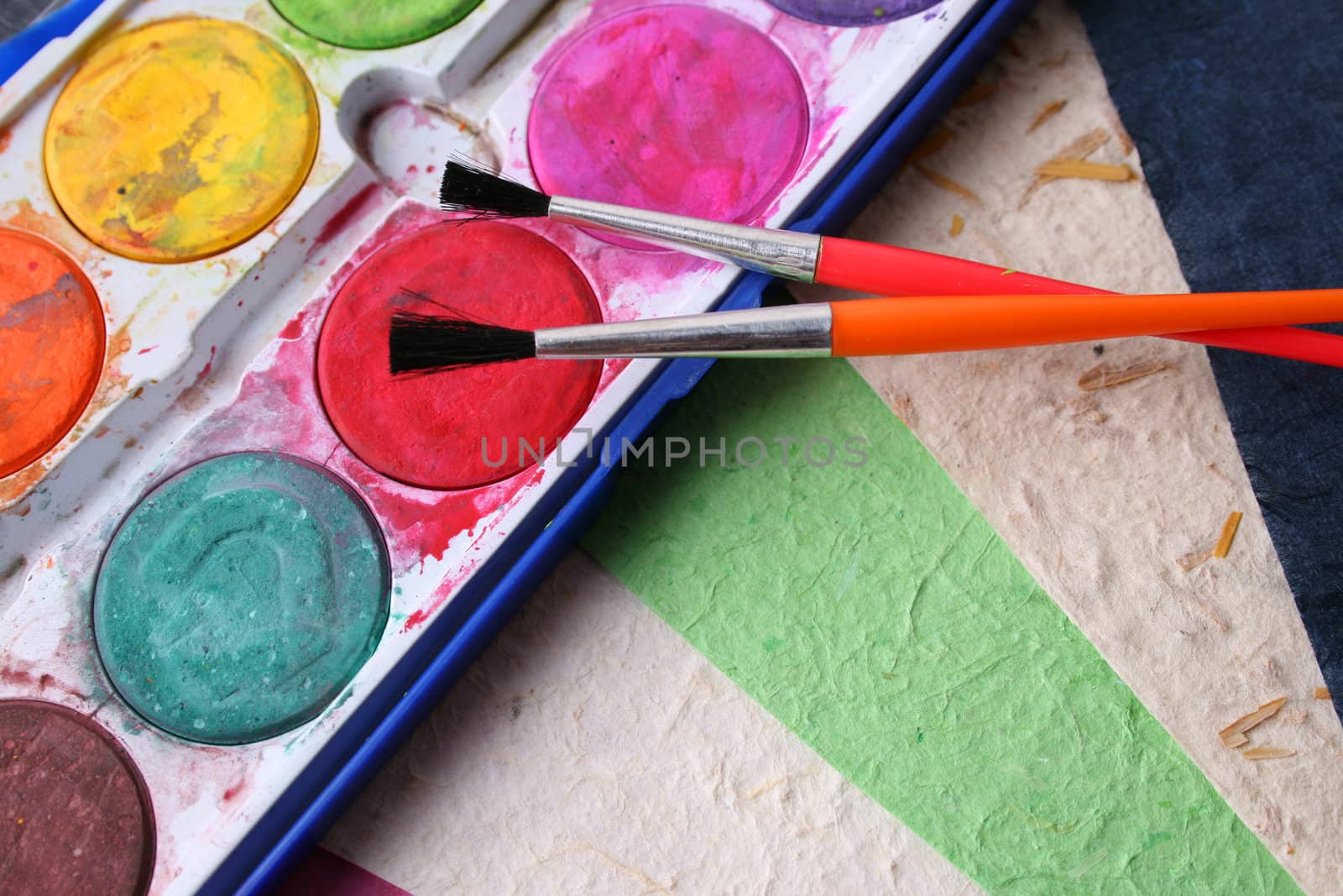 Paint Brushes, Paint and different colored handmade paper