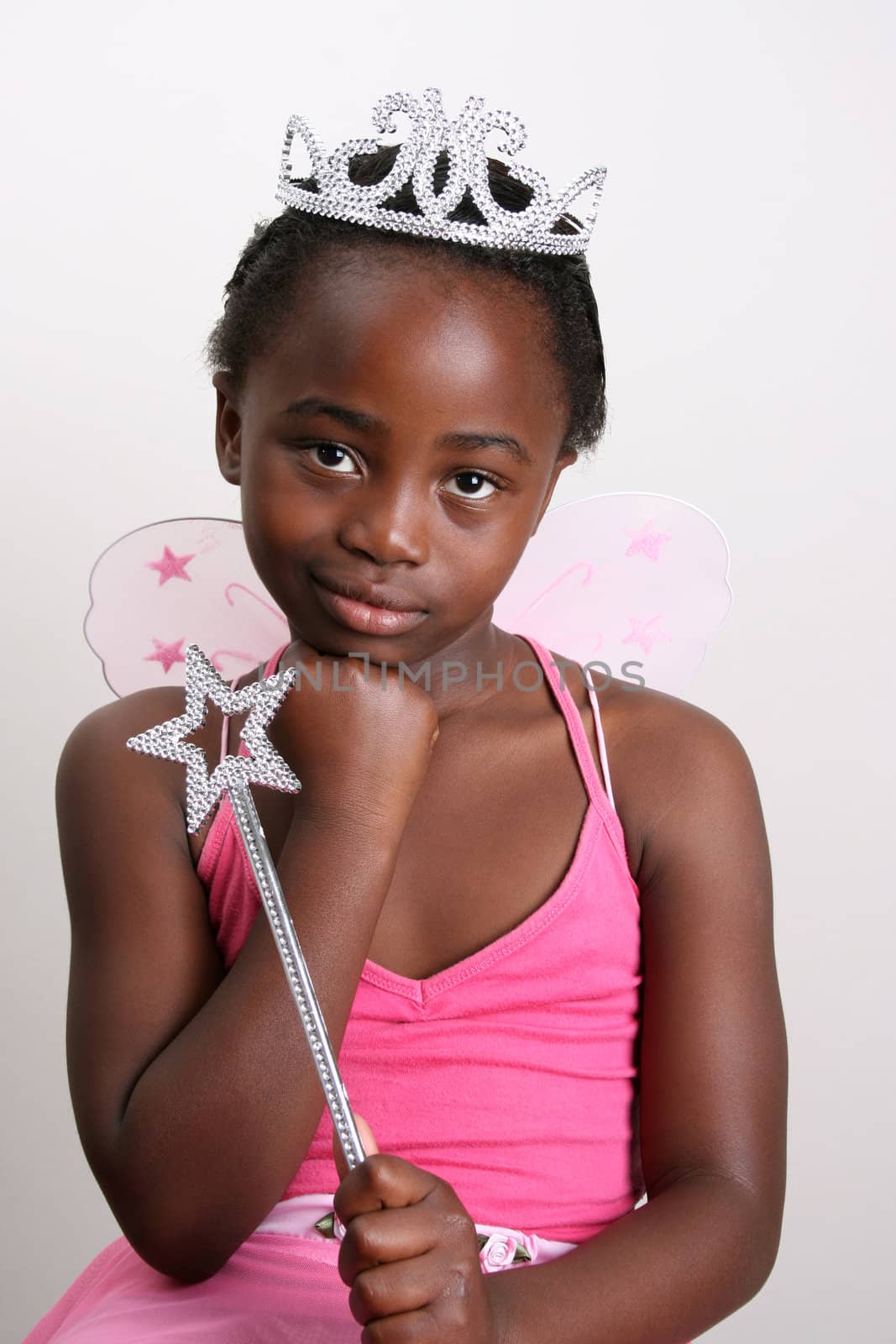 Young girl wearing a pink fairy costume with accessories