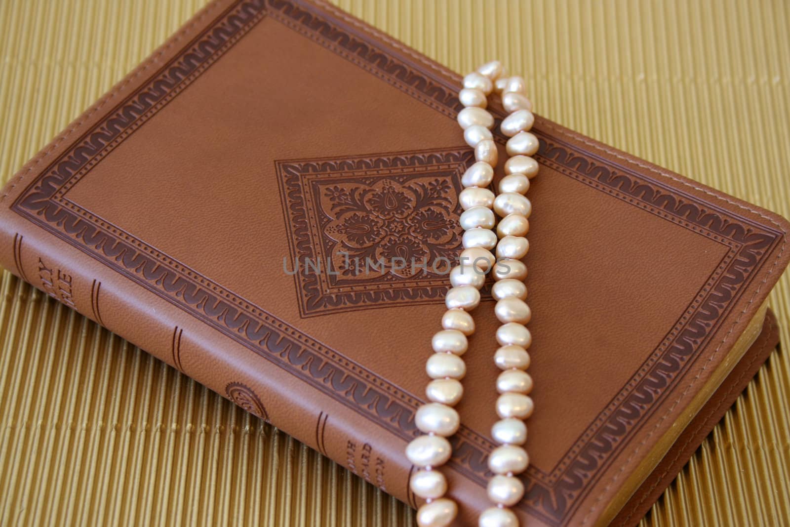 Pearls on a leather bound cover with patterns