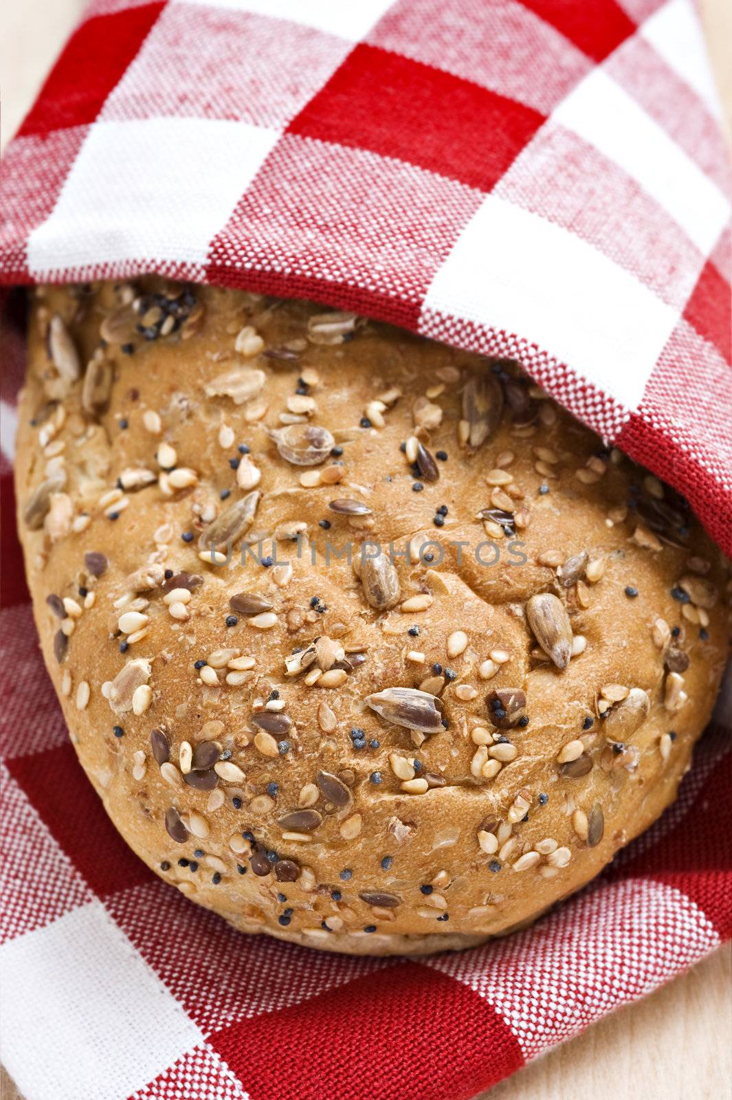 Whole wheat loaf in a red and white cloth ready to be served