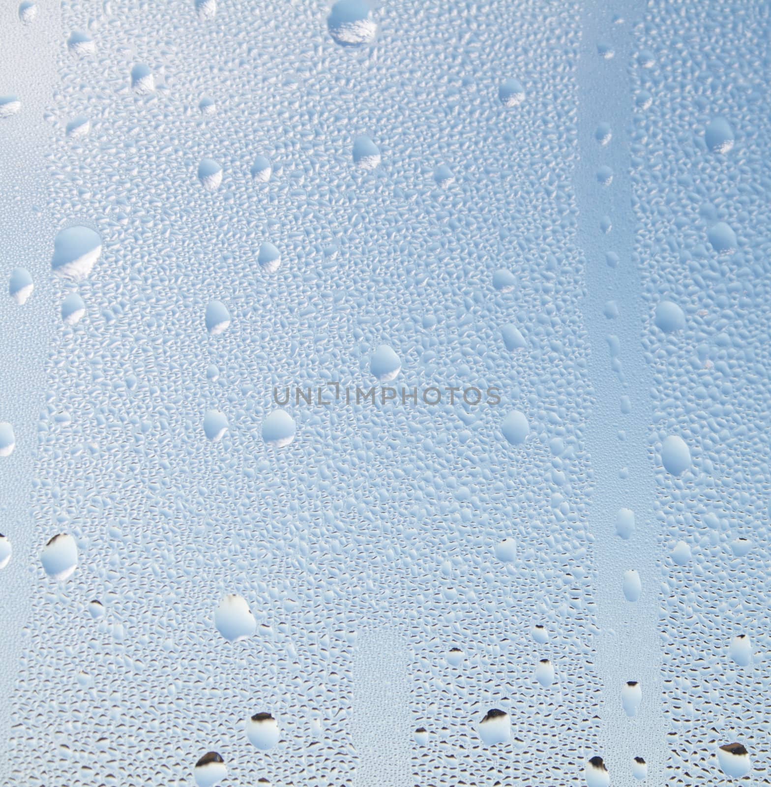 Water droplets in front of a blue sky background