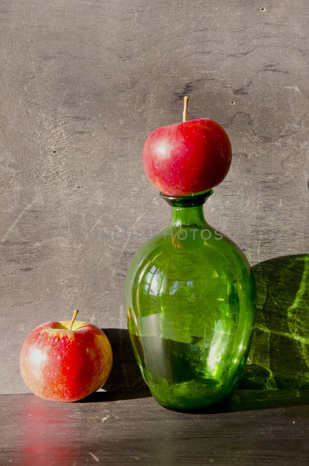 still-life with green bottle and two red apples