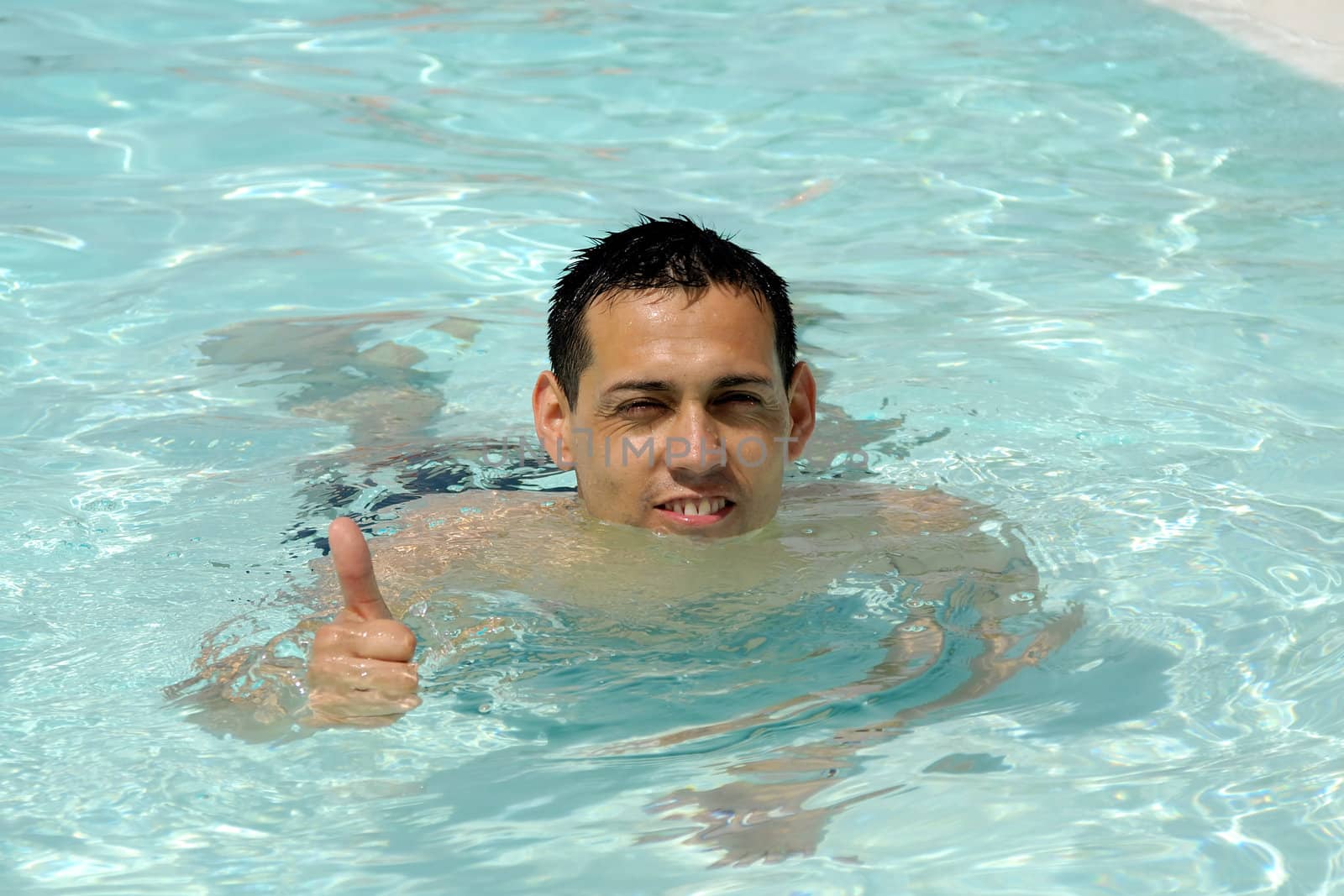 A happy man is making ok sign in pool