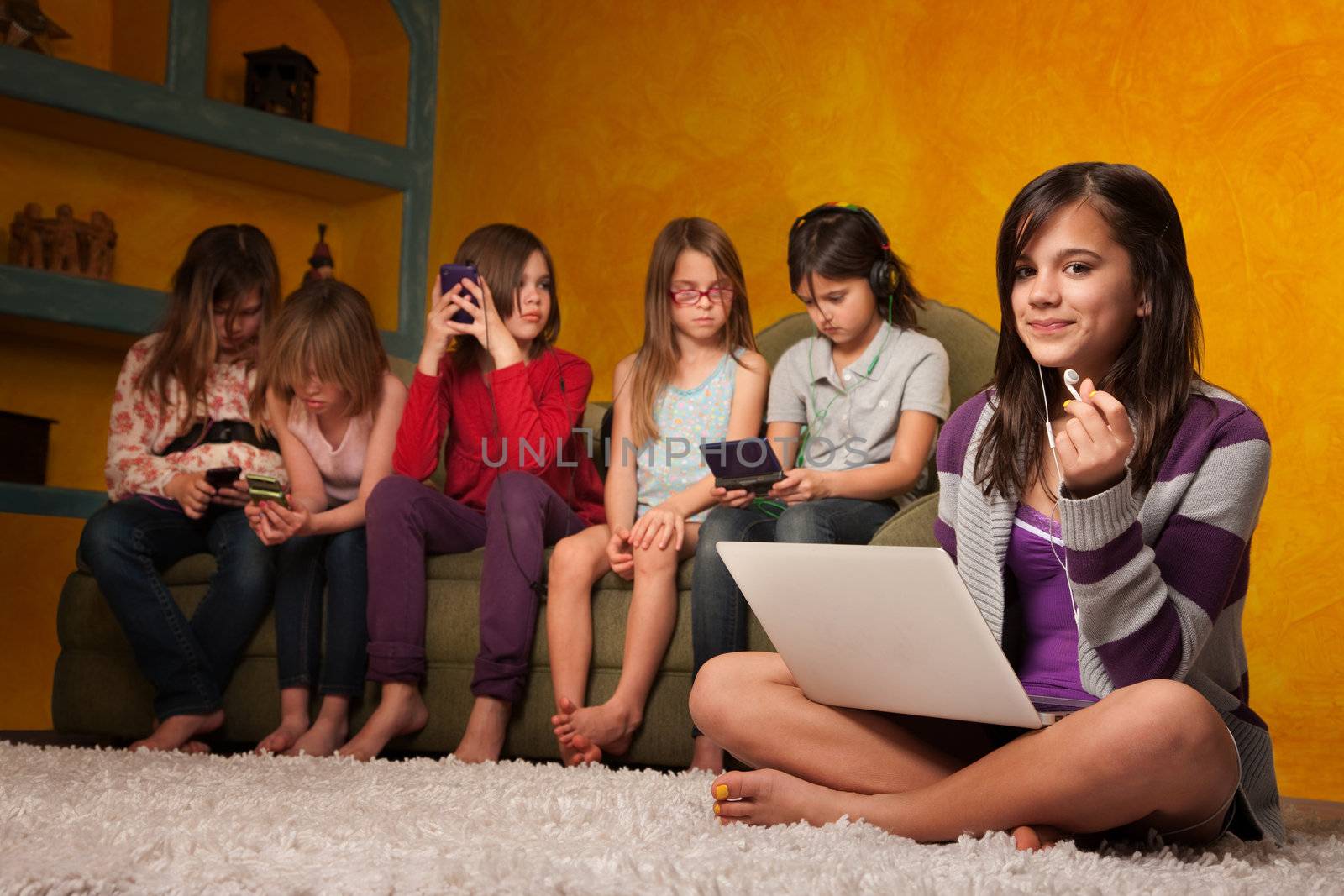 Caucasian girl with laptop while friends are busy with handheld devices