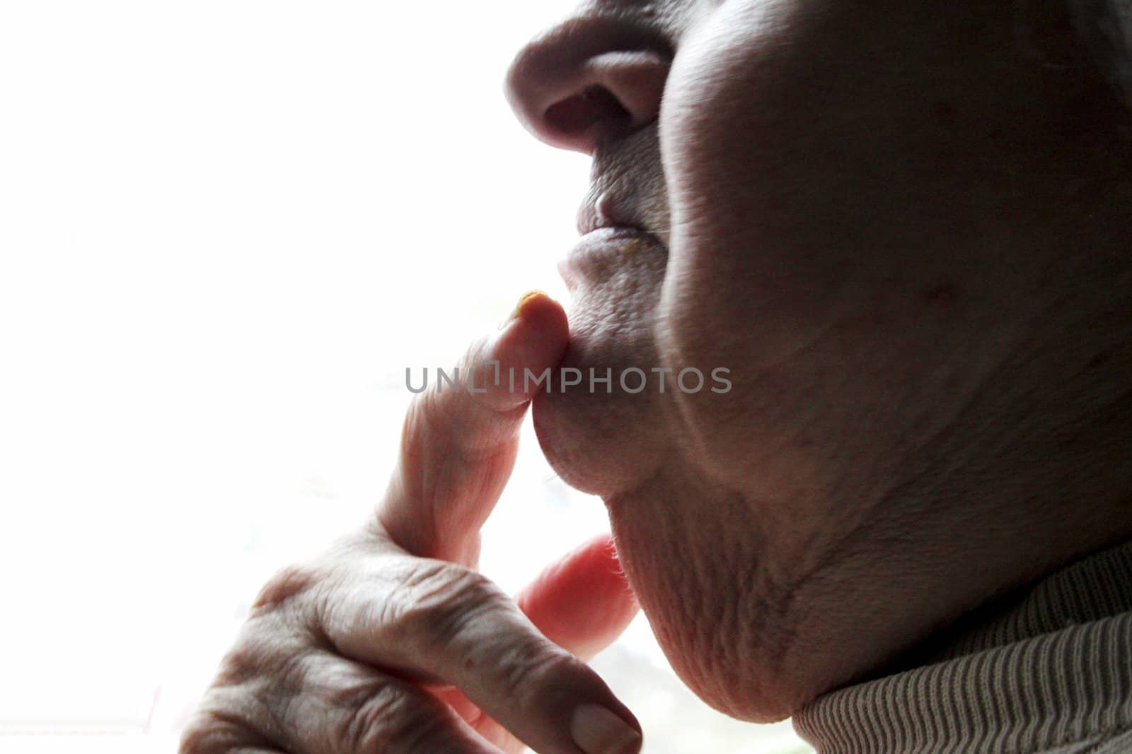 Finger resting on chin of an elderly lady
