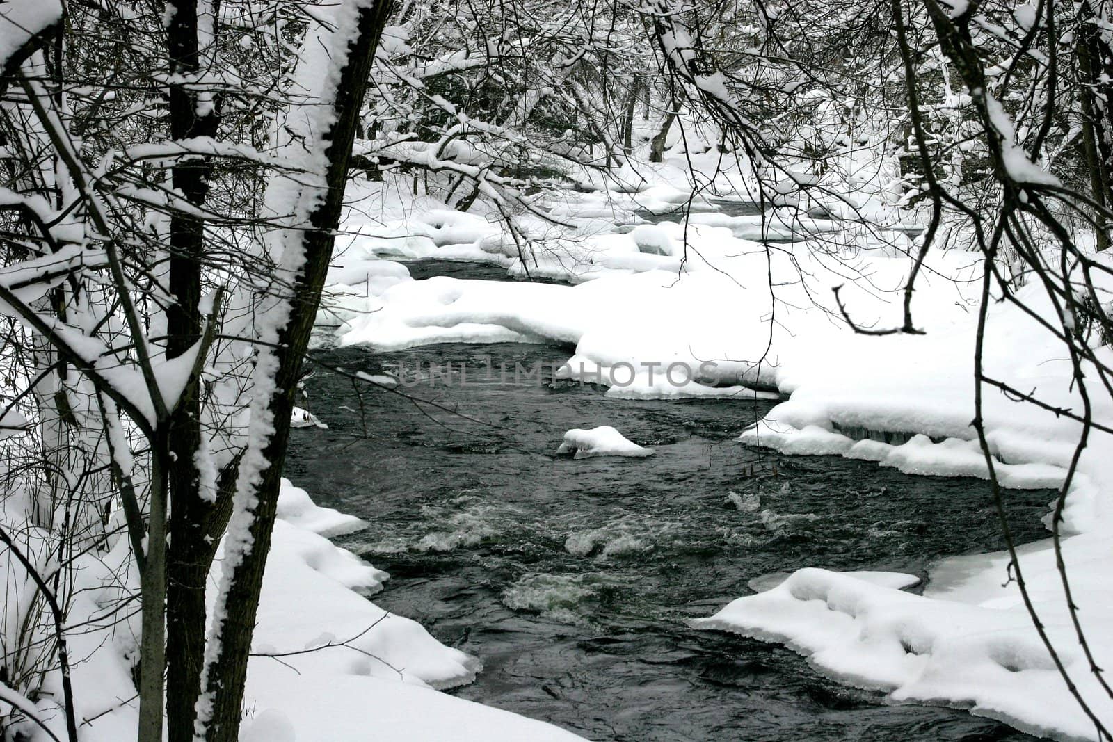 Small rapids on a river bend after a snow storm