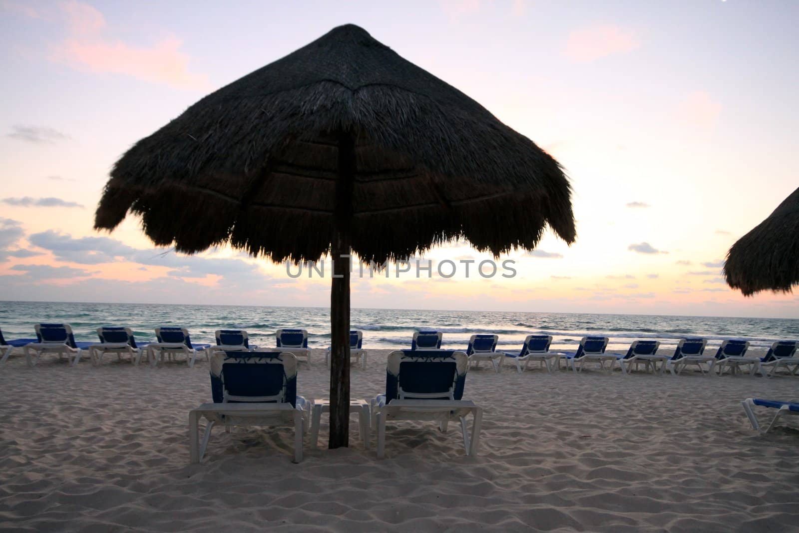 Palapas and chairs before sunrise in Riviera Maya