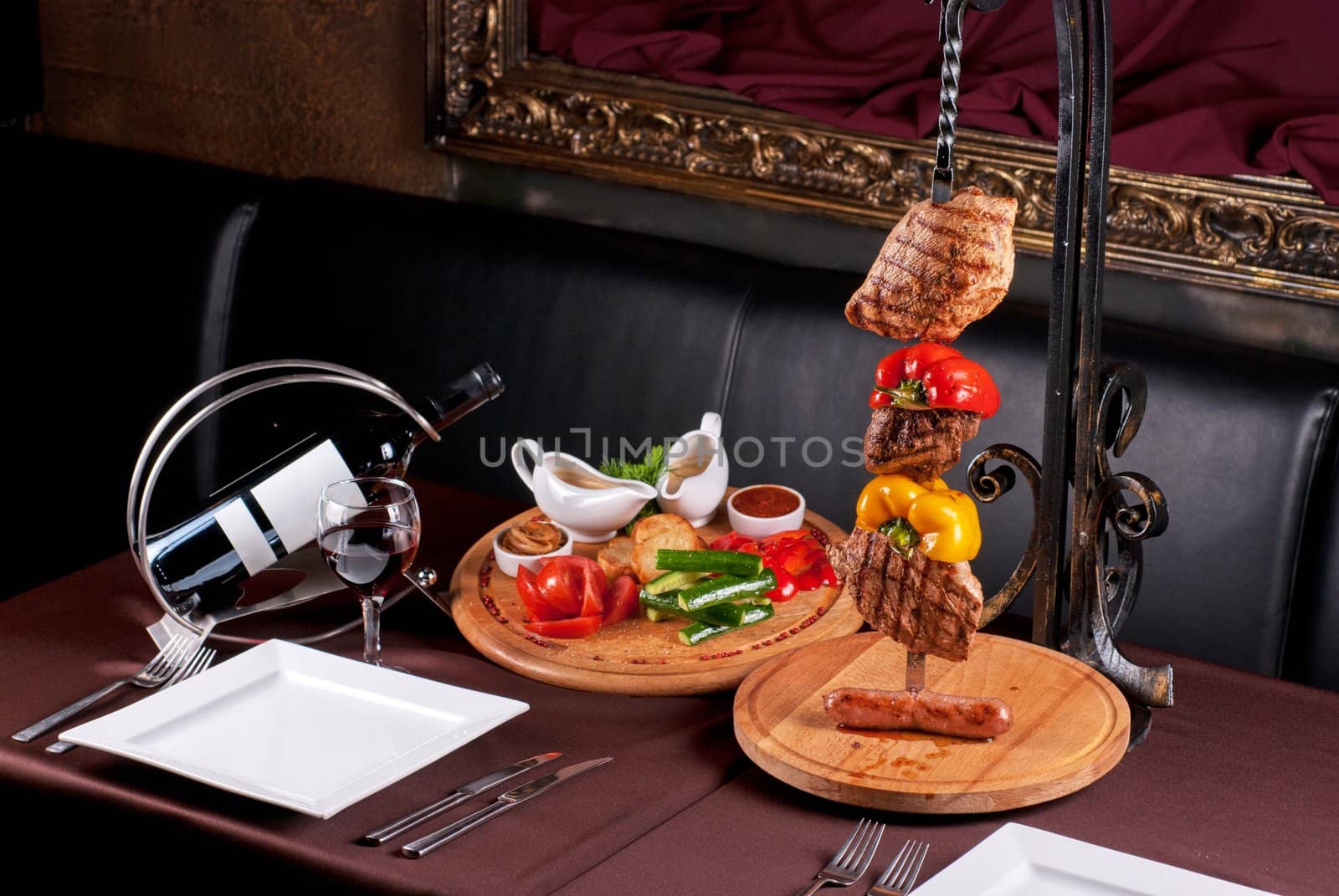 Big tasty roasted meat cuts at skewer on a decorated table
