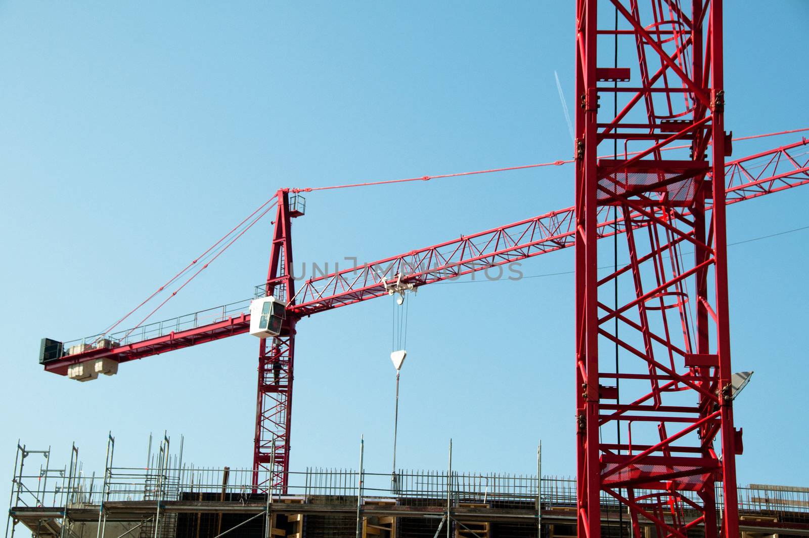 Construction site with red cranes and building
