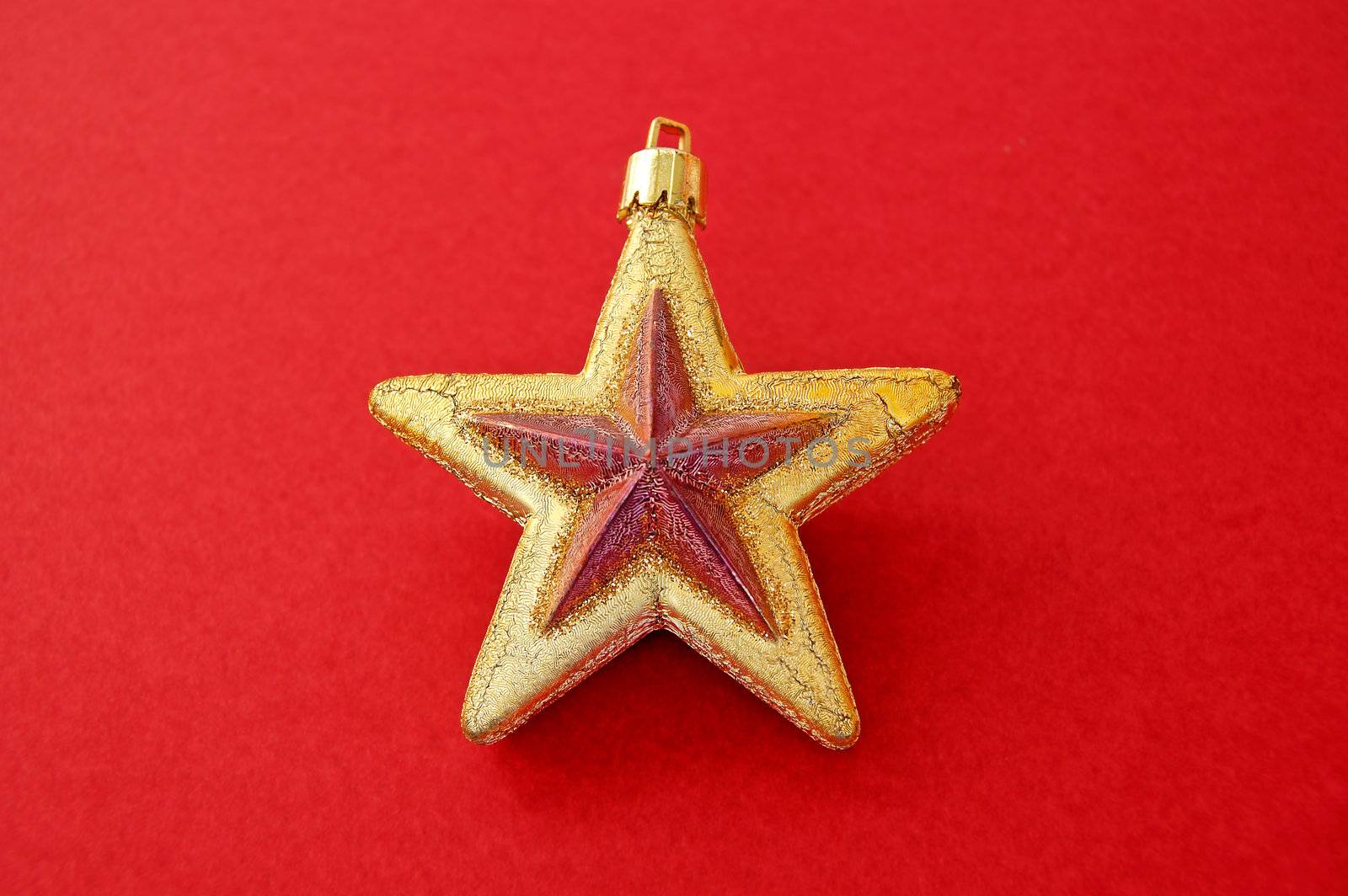 Christmas tree decoration. Golden star on red background.