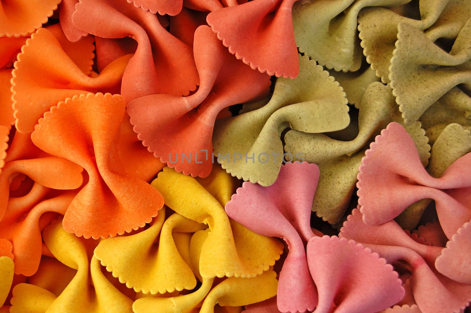 Four different flavors of farfalle bow ties pasta. Italian food background detail.