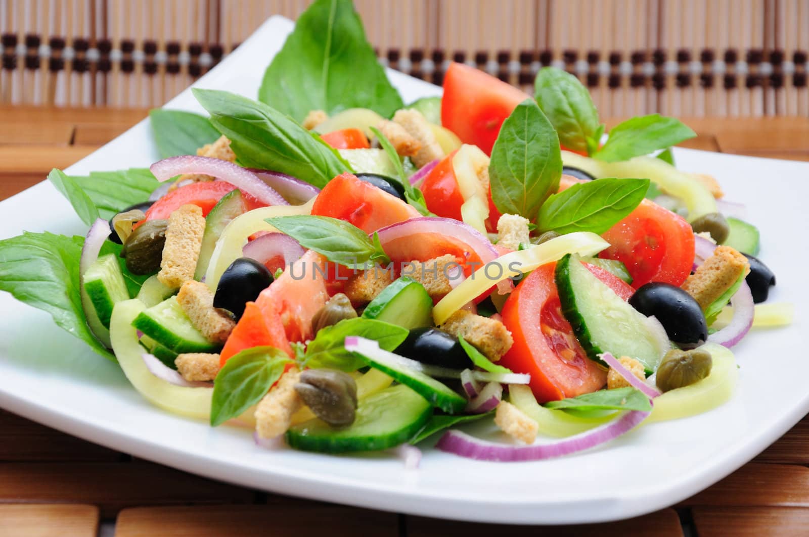 Fresh vegetable salad with basil, capers, olives, marinated with croutons