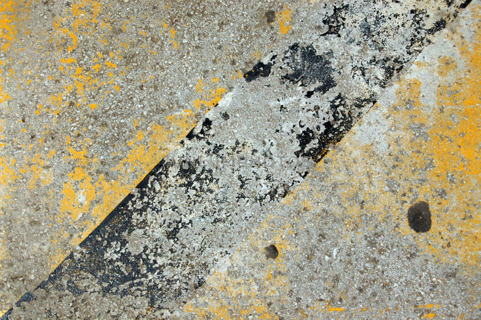 Concrete sidewalk with yellow and black paint.
