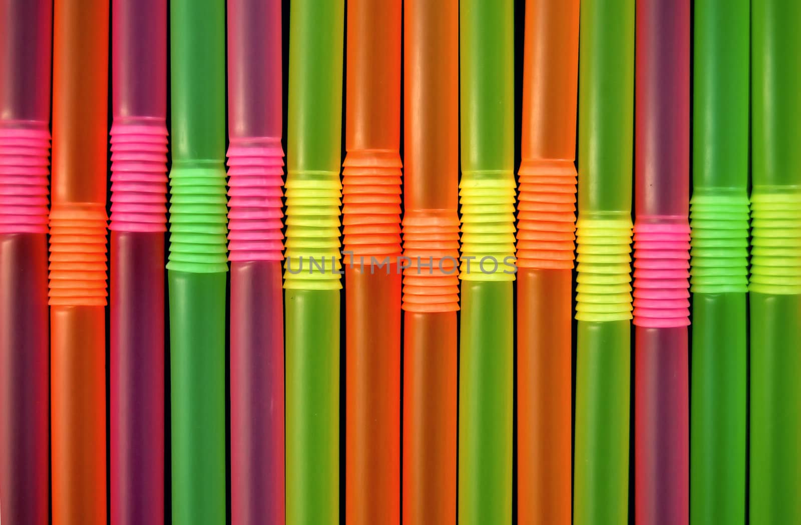 Drinking straws against a black background. Abstract pattern.