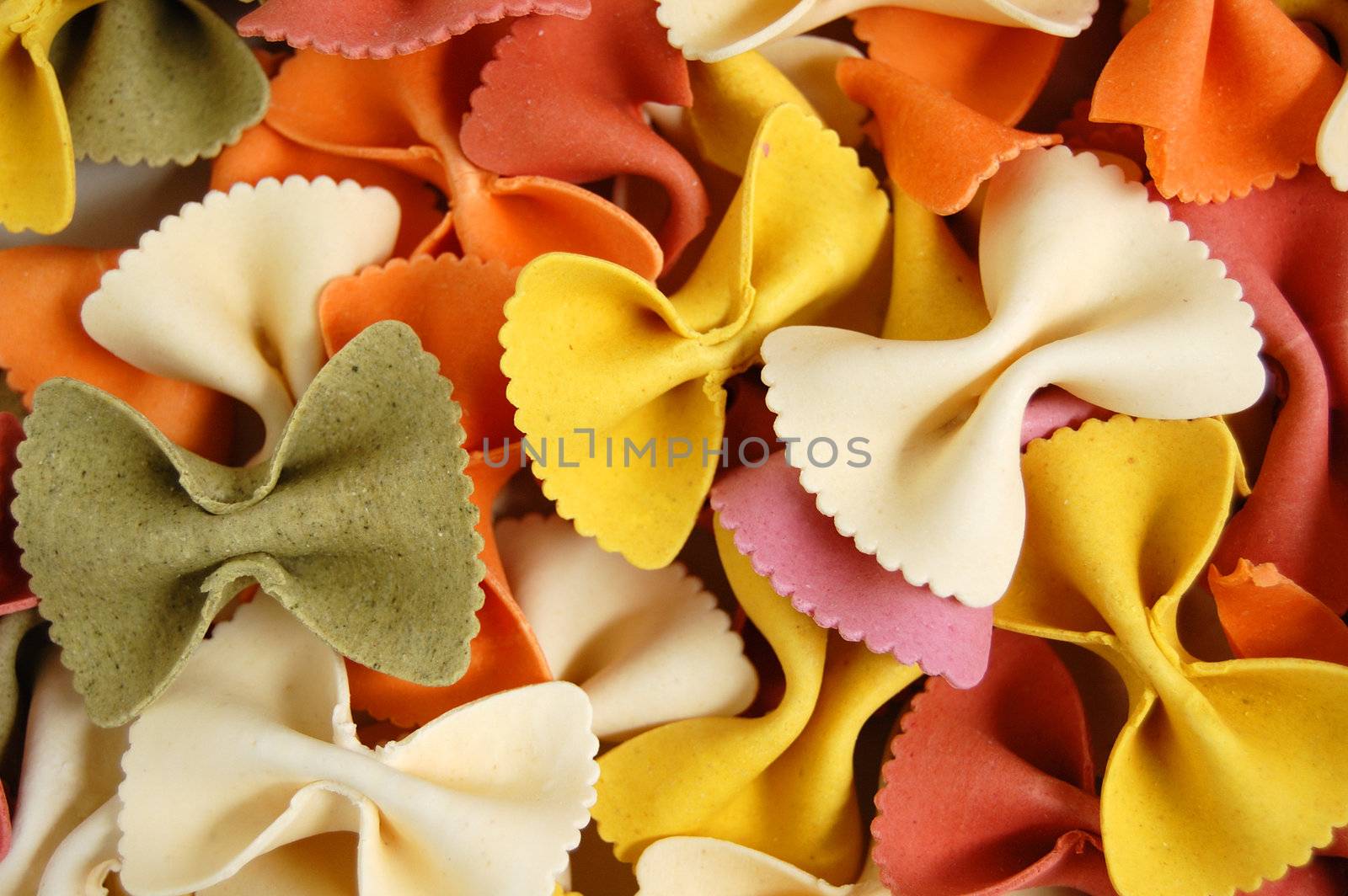 Many different flavors of fresh farfalle pasta. Italian food background.