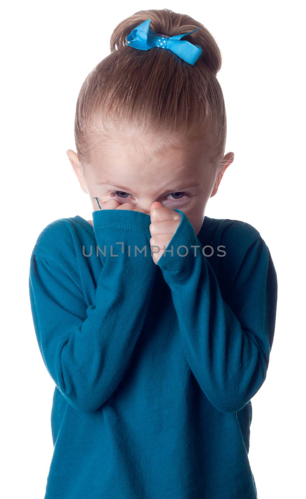 A girl in blue is hiding into her hands.