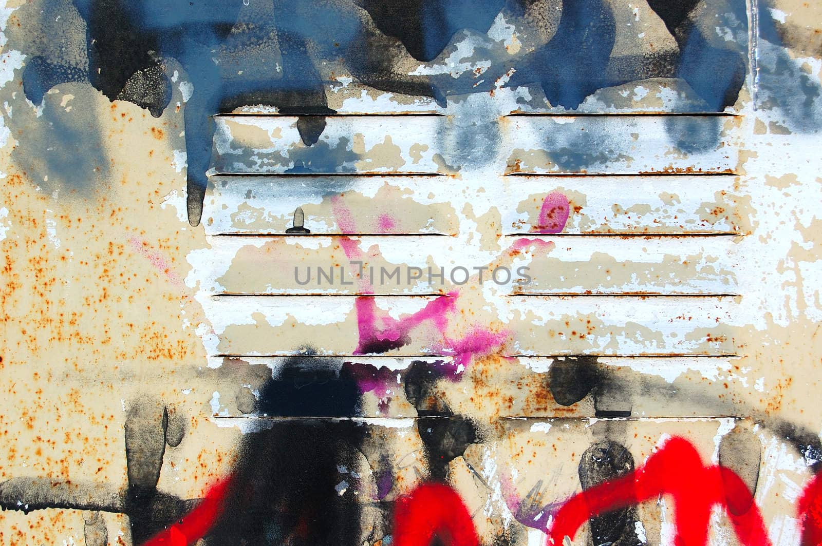 Detail of rusty metal surface covered with messy graffiti.