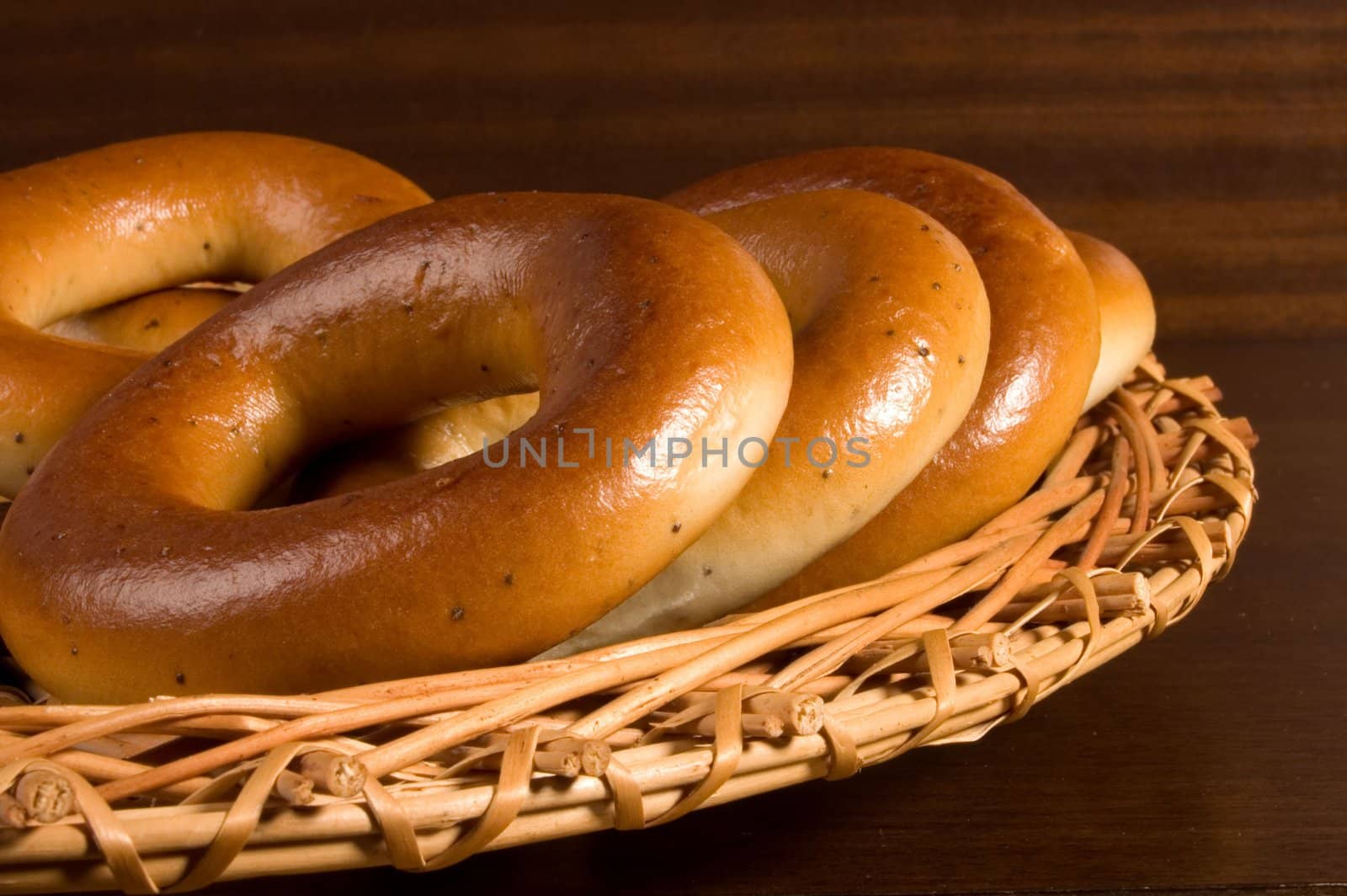 Appetizing bagels on wicker plate at the table