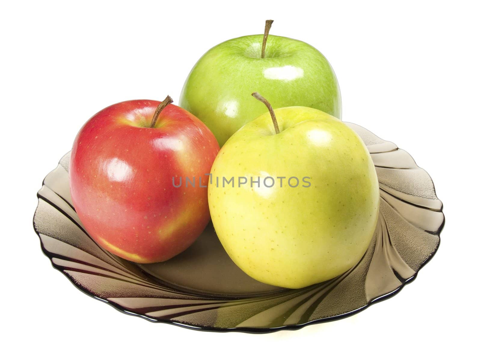 Three colored apples on wicker plate at the table