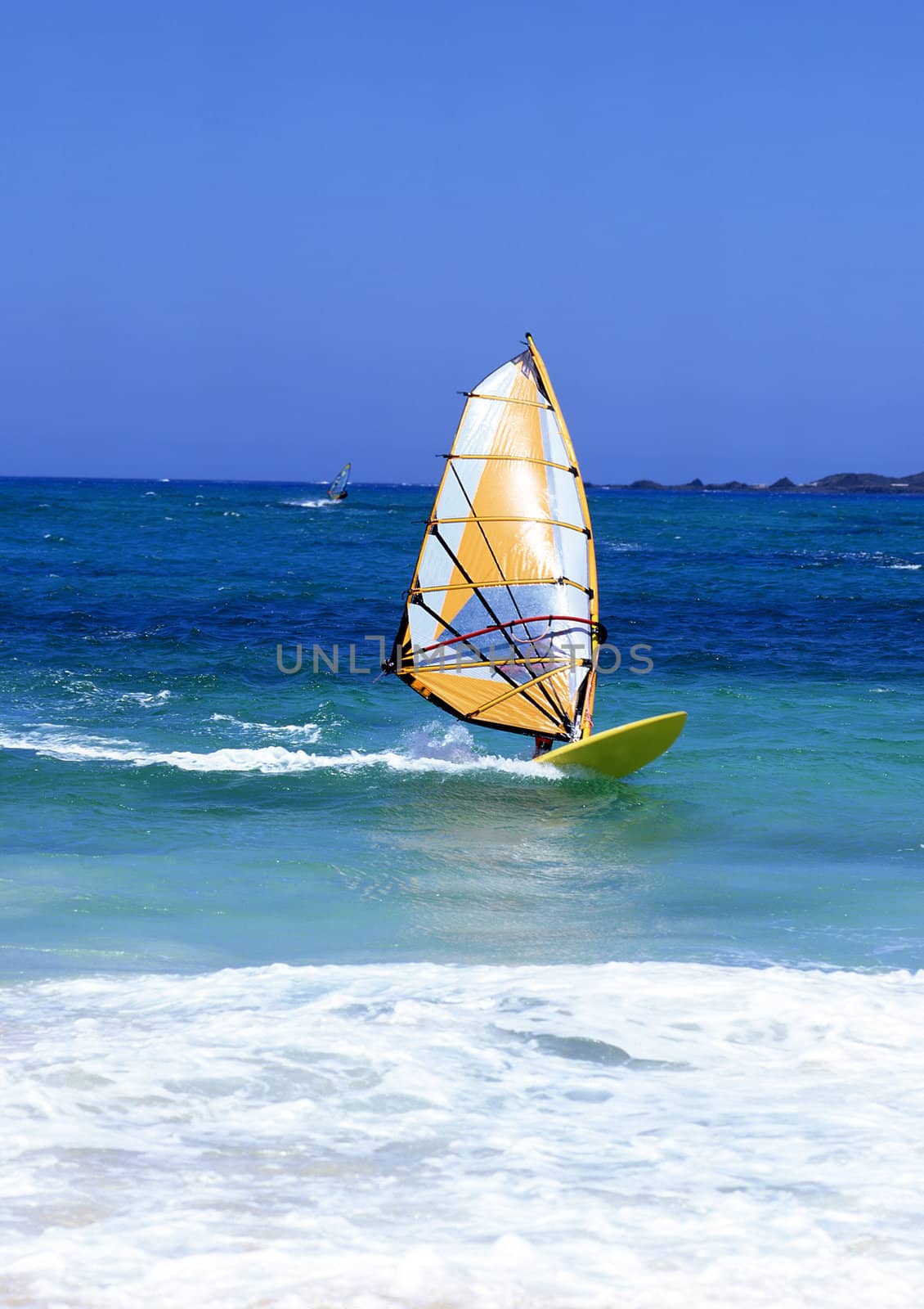 Windsurfer on Lanzarote, Canary Islands in a turquoise sea with white surf