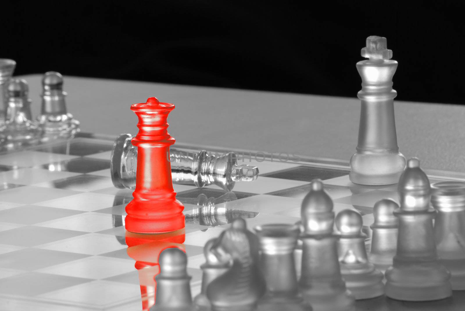 Horizontal image of a glass chess set, rendered in black and white with the conquering queen colored red.