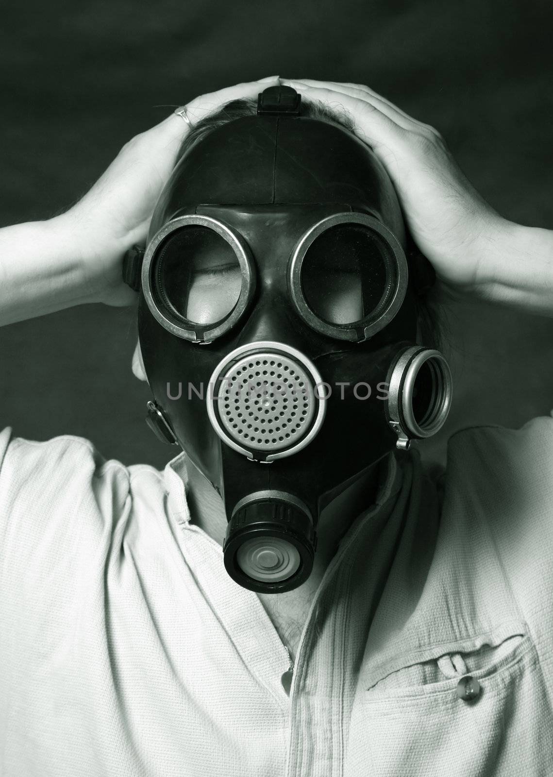 The person in a gas mask holds hands a head