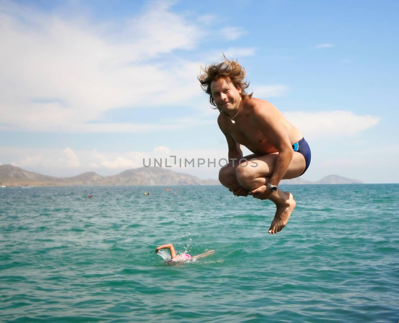 Jumping happy man over water