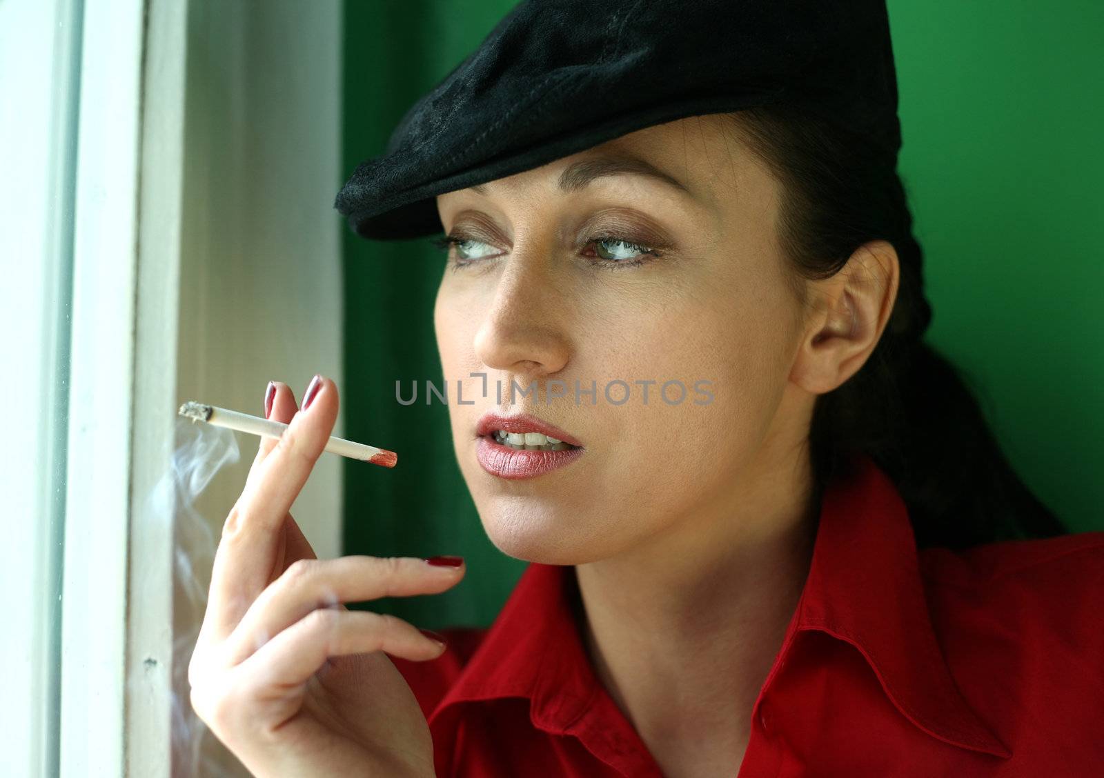 Woman with a cigarette on green background