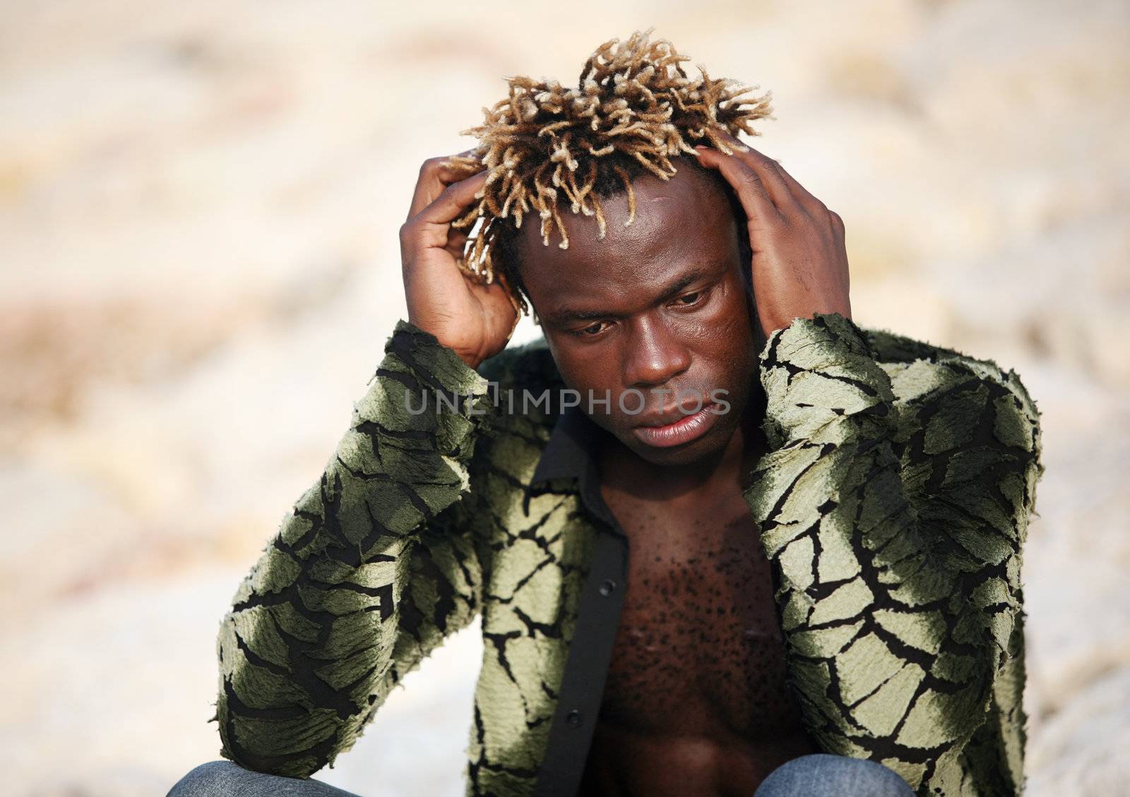 Portrait of young sad African descent man in green t-shirt on beige background. Indonesia