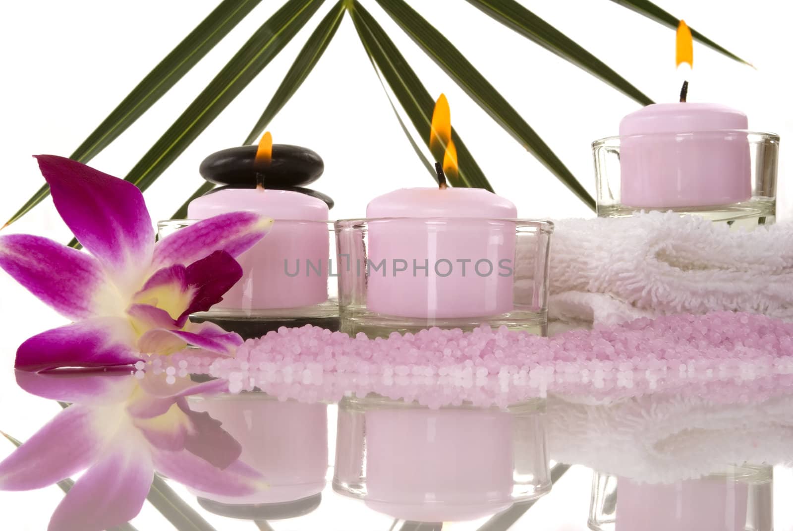 Orchids, towel, candles, pebbles and aromatic bath salt in a spa