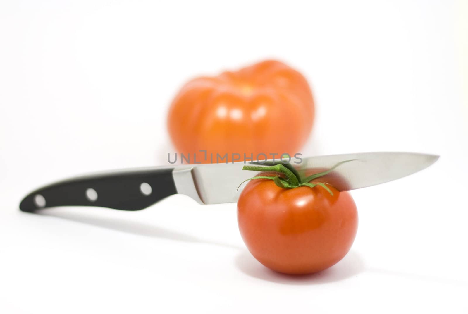 Knife and tomato isolated on white
