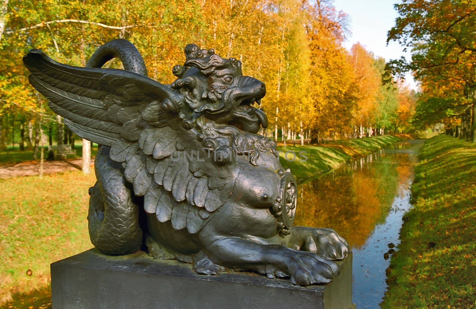 Sculpture of the Dragon on foreground of the autumn landscape